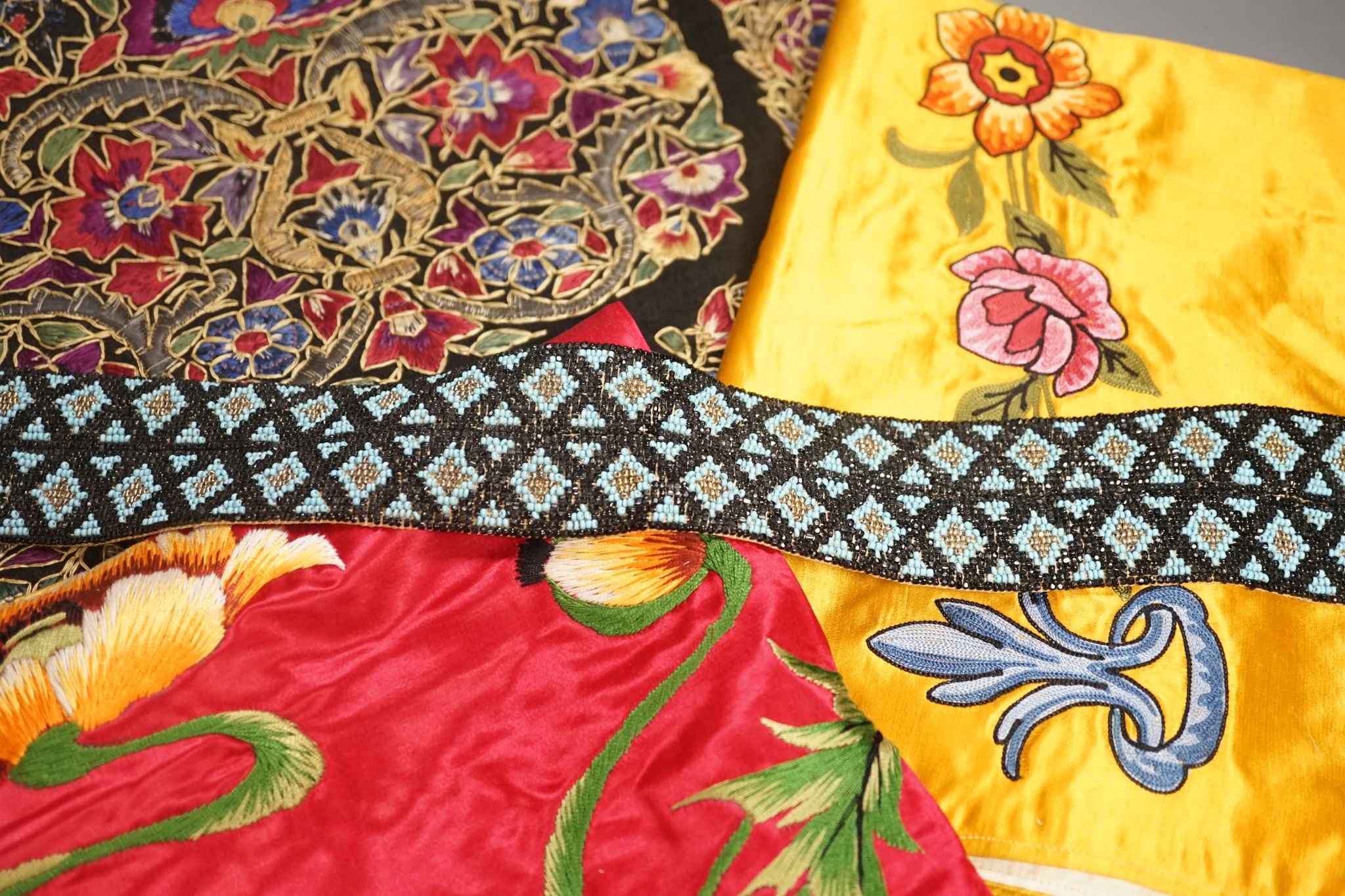 A Berlin beadwork panel , another, a beaded cushion, a book and embroidered banners, 2 silk panels etc